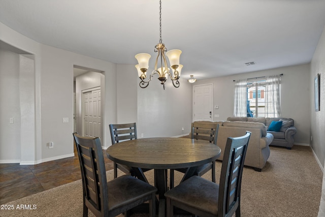 carpeted dining space featuring an inviting chandelier