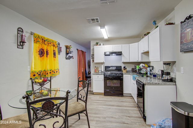 kitchen with white cabinetry, black appliances, light stone counters, and light hardwood / wood-style flooring