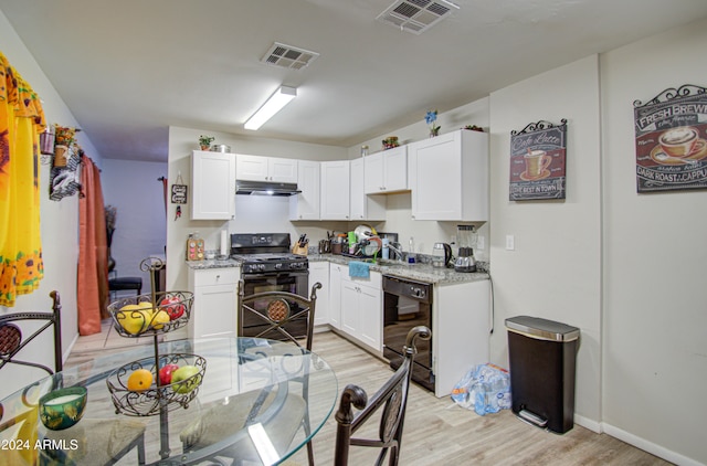 kitchen featuring light hardwood / wood-style floors, white cabinetry, and black appliances