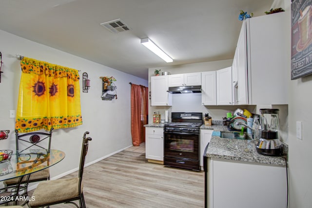 kitchen with sink, light stone countertops, light hardwood / wood-style flooring, white cabinets, and black gas stove