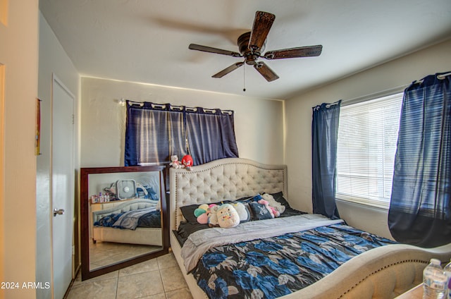 tiled bedroom featuring ceiling fan