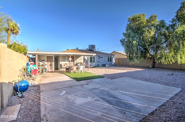 back of property with central air condition unit and a patio area