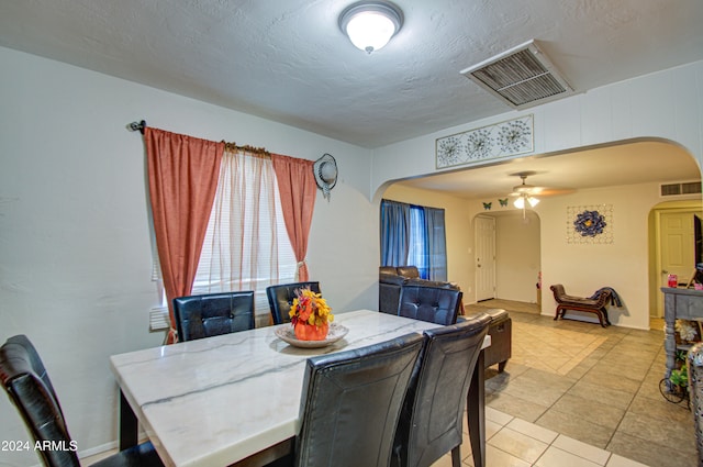 dining room featuring a textured ceiling, ceiling fan, and light tile patterned floors