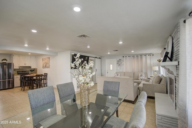 tiled dining area featuring a barn door