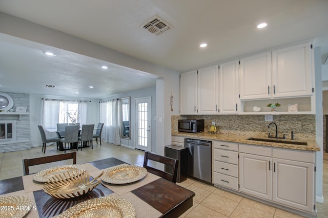 kitchen featuring white cabinetry, dishwasher, sink, and light stone counters