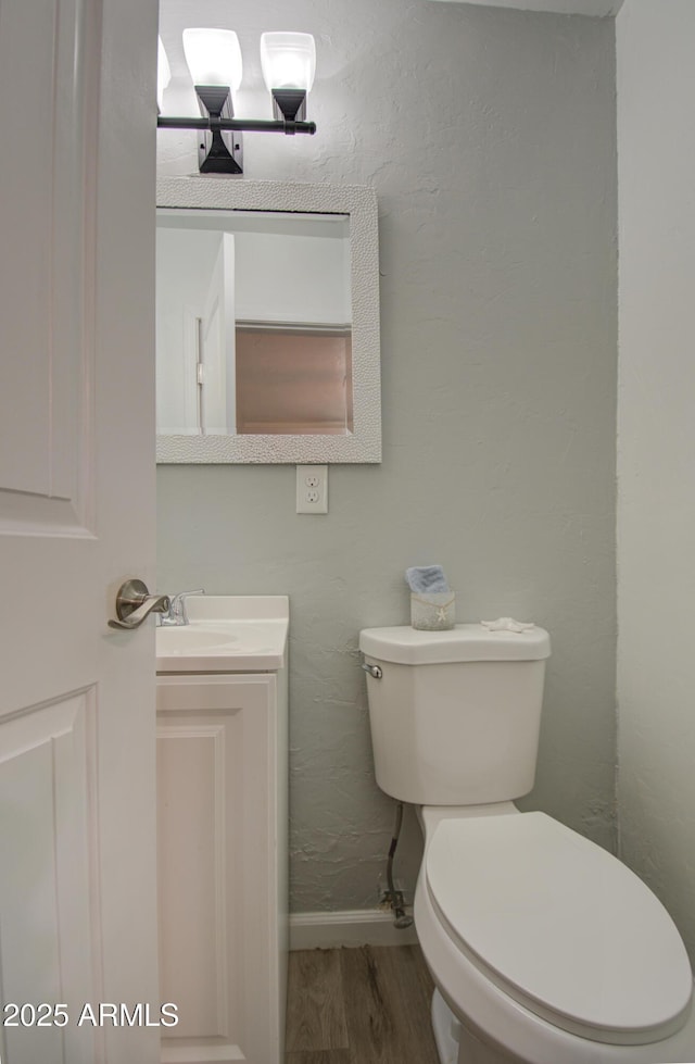 bathroom with hardwood / wood-style flooring, vanity, and toilet