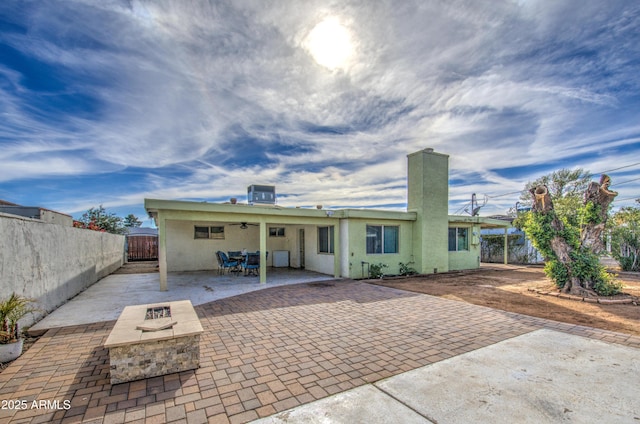 rear view of property featuring central AC, an outdoor fire pit, and a patio area