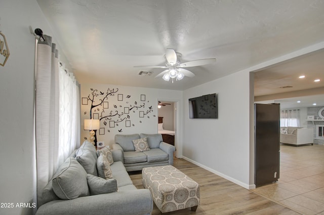 living room with ceiling fan and light hardwood / wood-style flooring