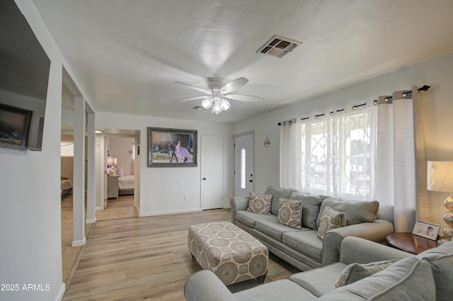 living room featuring light hardwood / wood-style flooring and ceiling fan