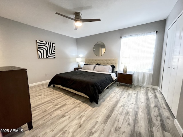 bedroom with ceiling fan, light hardwood / wood-style floors, and a closet