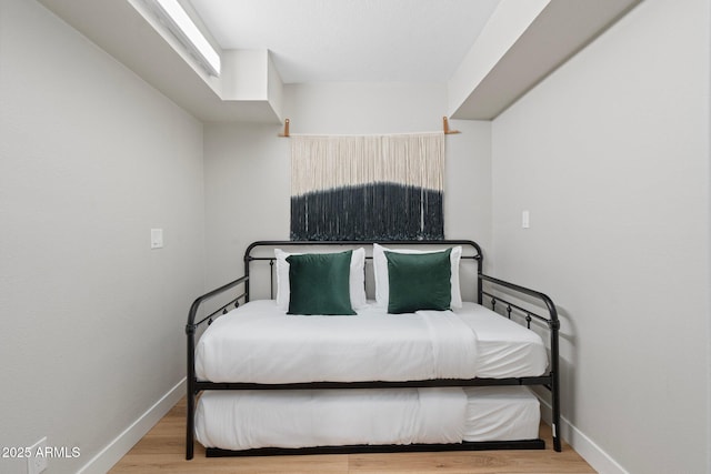 bedroom featuring baseboards and wood finished floors