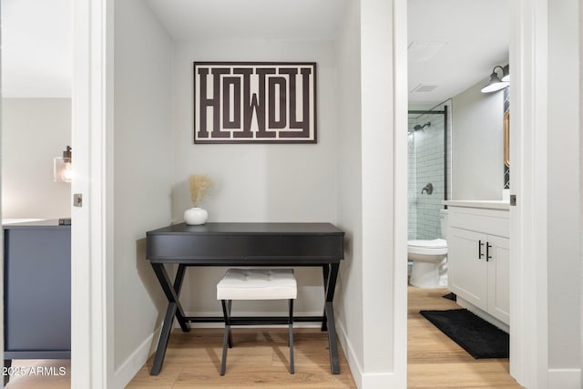 full bath featuring toilet, baseboards, a tile shower, and wood finished floors