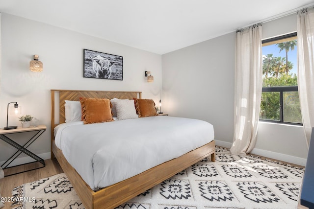 bedroom with baseboards and wood finished floors