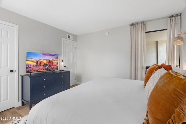 bedroom with light wood-style floors and visible vents