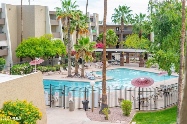 pool with a patio and fence