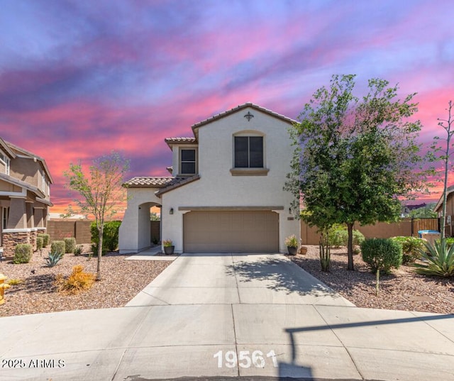 19561 W Woodlands Ave, Buckeye, AZ 85326 - mediterranean / spanish-style home featuring stucco siding, driveway, an attached garage, a tile roof, and fence