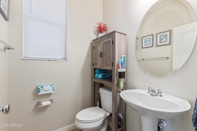 19561 W Woodlands Ave, Buckeye, AZ 85326 - bathroom featuring toilet, a sink, and baseboards