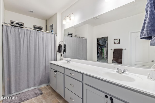 19561 W Woodlands Ave, Buckeye, AZ 85326 - full bath featuring double vanity, visible vents, a sink, and curtained shower