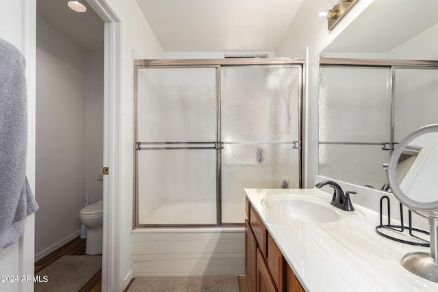 bathroom featuring vanity, toilet, and an enclosed shower