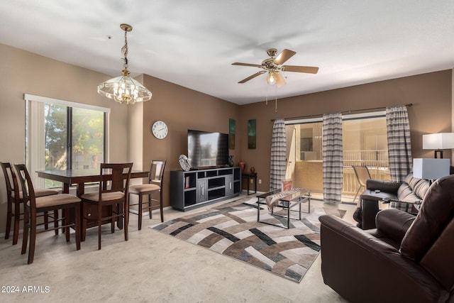 living room with ceiling fan with notable chandelier