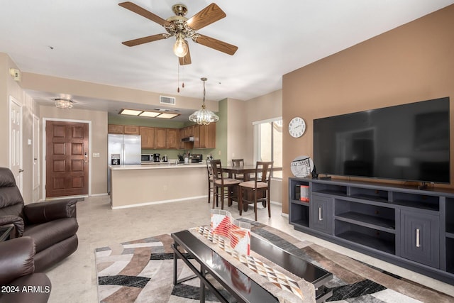 living room with ceiling fan with notable chandelier