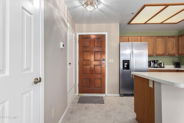 kitchen featuring stainless steel refrigerator with ice dispenser and a textured ceiling