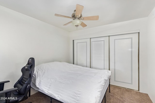 carpeted bedroom featuring a closet and ceiling fan