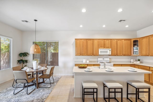 35402 N 32nd Dr, Phoenix, AZ 85086 - kitchen with white appliances, a breakfast bar, glass insert cabinets, light countertops, and a kitchen island