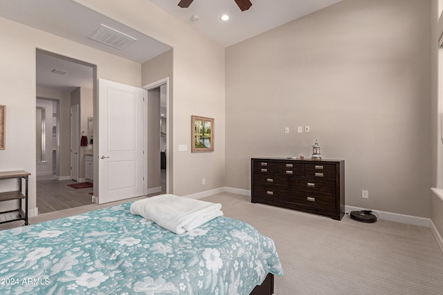 carpeted bedroom featuring ensuite bath and ceiling fan