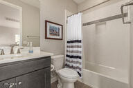 full bathroom with vanity, shower / bath combination with curtain, and toilet