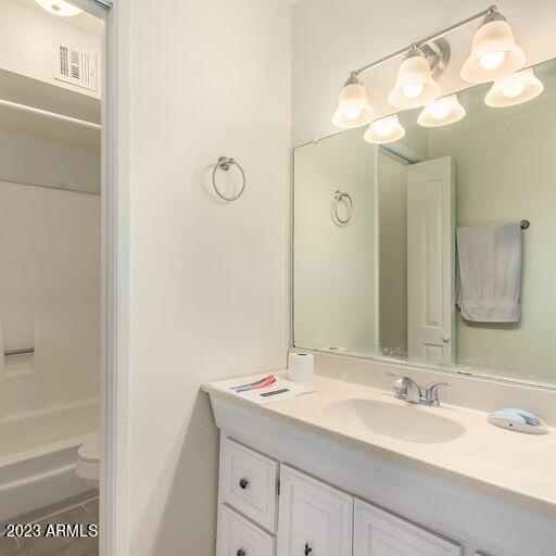 bathroom with walk in shower, tile patterned flooring, vanity, and toilet