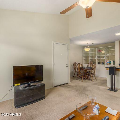 living room featuring ceiling fan, carpet, and high vaulted ceiling