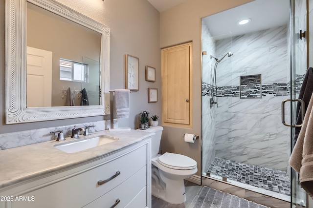 bathroom with vanity, toilet, and a shower stall