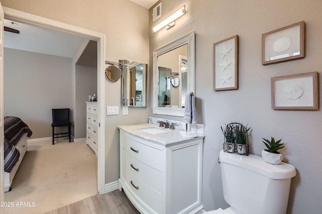 bathroom featuring vanity, toilet, baseboards, and visible vents