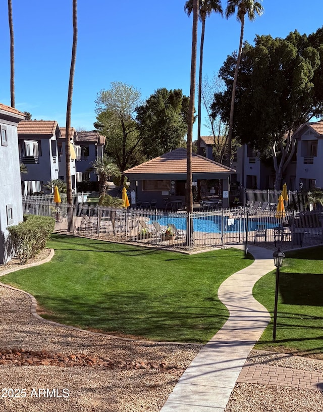 view of home's community featuring a lawn, fence, a gazebo, a residential view, and a pool