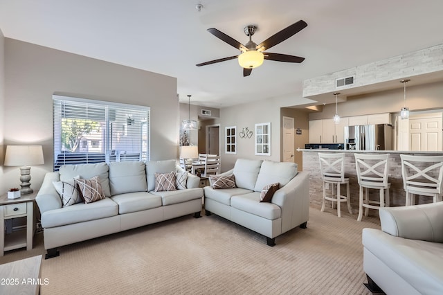 living room with light carpet, visible vents, and ceiling fan