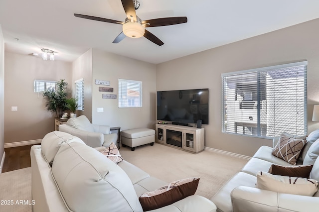 living room featuring baseboards, plenty of natural light, and a ceiling fan