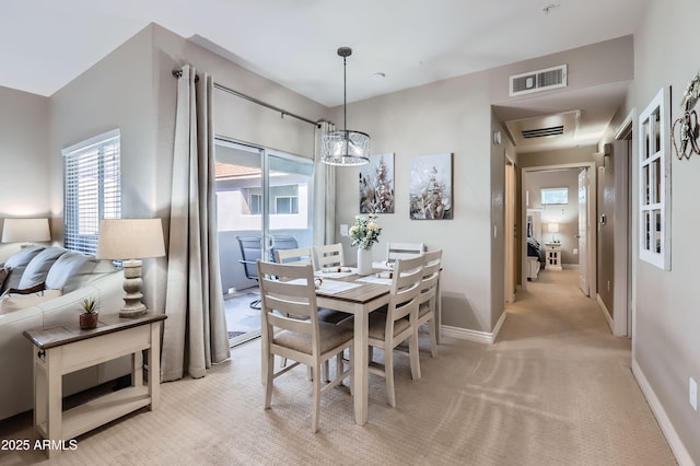 dining area featuring light carpet, visible vents, and baseboards