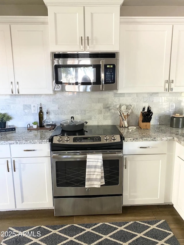 2100 N Normal Ave, Tempe, AZ 85288 - kitchen with appliances with stainless steel finishes, dark wood-style floors, white cabinets, and tasteful backsplash