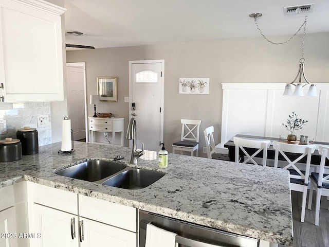 2100 N Normal Ave, Tempe, AZ 85288 - kitchen featuring stainless steel dishwasher, white cabinetry, light stone counters, backsplash, and hanging light fixtures