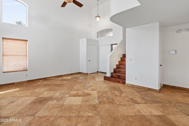 20809 N 1st Ave, Phoenix, AZ 85027 - unfurnished living room featuring a high ceiling, ceiling fan, baseboards, stairs, and light stone finish floors