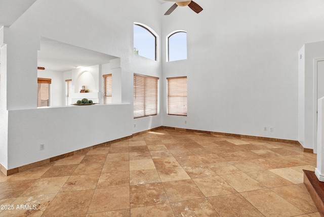 20809 N 1st Ave, Phoenix, AZ 85027 - unfurnished living room featuring ceiling fan, a towering ceiling, and baseboards