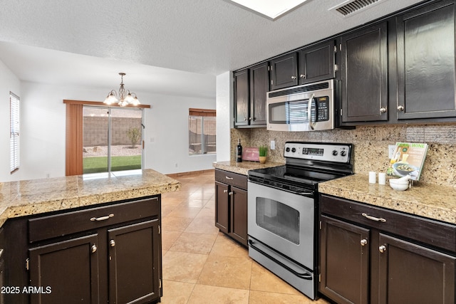 20809 N 1st Ave, Phoenix, AZ 85027 - kitchen with stainless steel appliances, a chandelier, tasteful backsplash, light tile patterned floors, and a textured ceiling