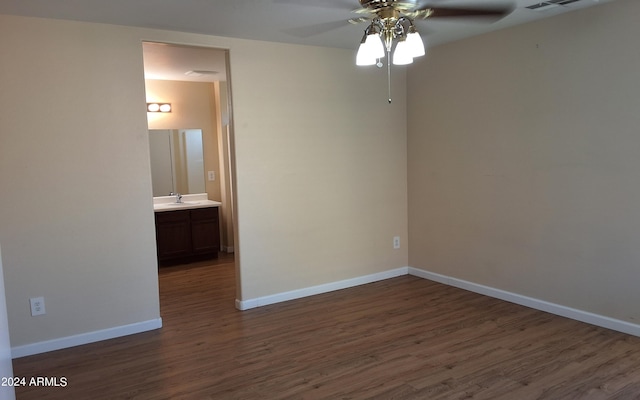 unfurnished room with ceiling fan, sink, and dark wood-type flooring