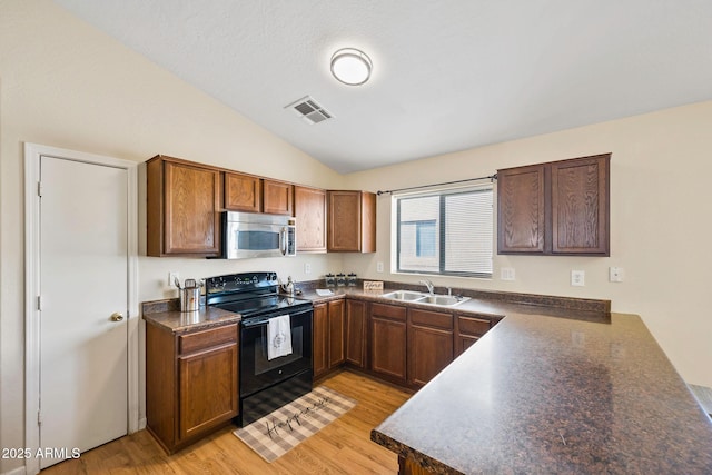 kitchen featuring a sink, visible vents, black electric range, stainless steel microwave, and dark countertops