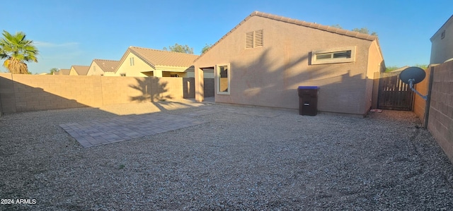 rear view of house with a patio area, a tile roof, a fenced backyard, and stucco siding