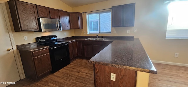 kitchen featuring light hardwood / wood-style floors, kitchen peninsula, sink, and black electric range