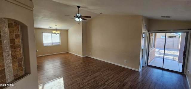 empty room featuring ceiling fan with notable chandelier, dark hardwood / wood-style flooring, and vaulted ceiling