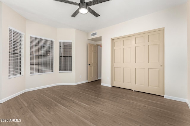 unfurnished bedroom with ceiling fan, a closet, and wood-type flooring