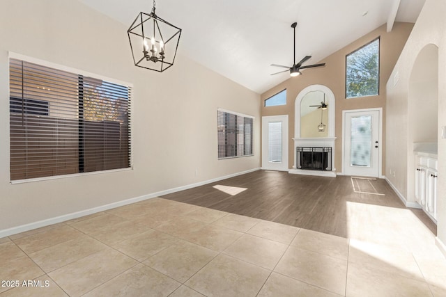 unfurnished living room with ceiling fan with notable chandelier, high vaulted ceiling, beam ceiling, and light tile patterned floors